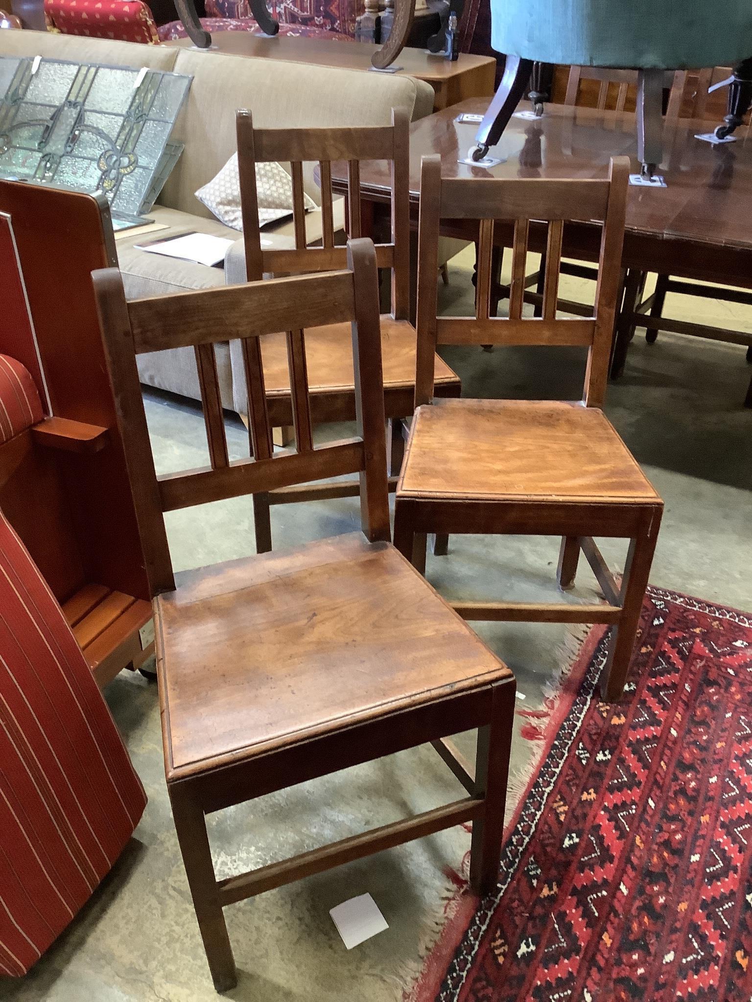 A set of six 19th century provincial fruitwood solid seat dining chairs, one with arms.